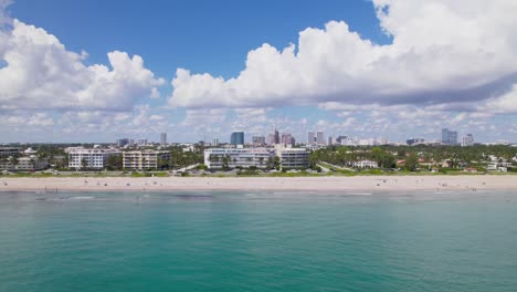 gorgeous pan up shot of aerial drone view of west palm beach coastline skyline downtown area and beautiful beach sand and boats in water