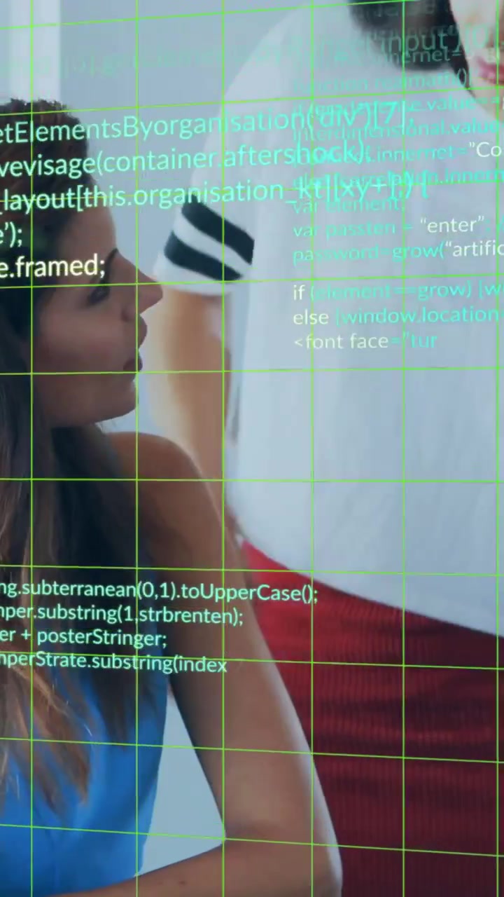 Video verticale: Un collega in piedi si avvicina e sollecita la persona seduta che usa una penna su un taccuino, con una griglia di codice che scorre per la revisione