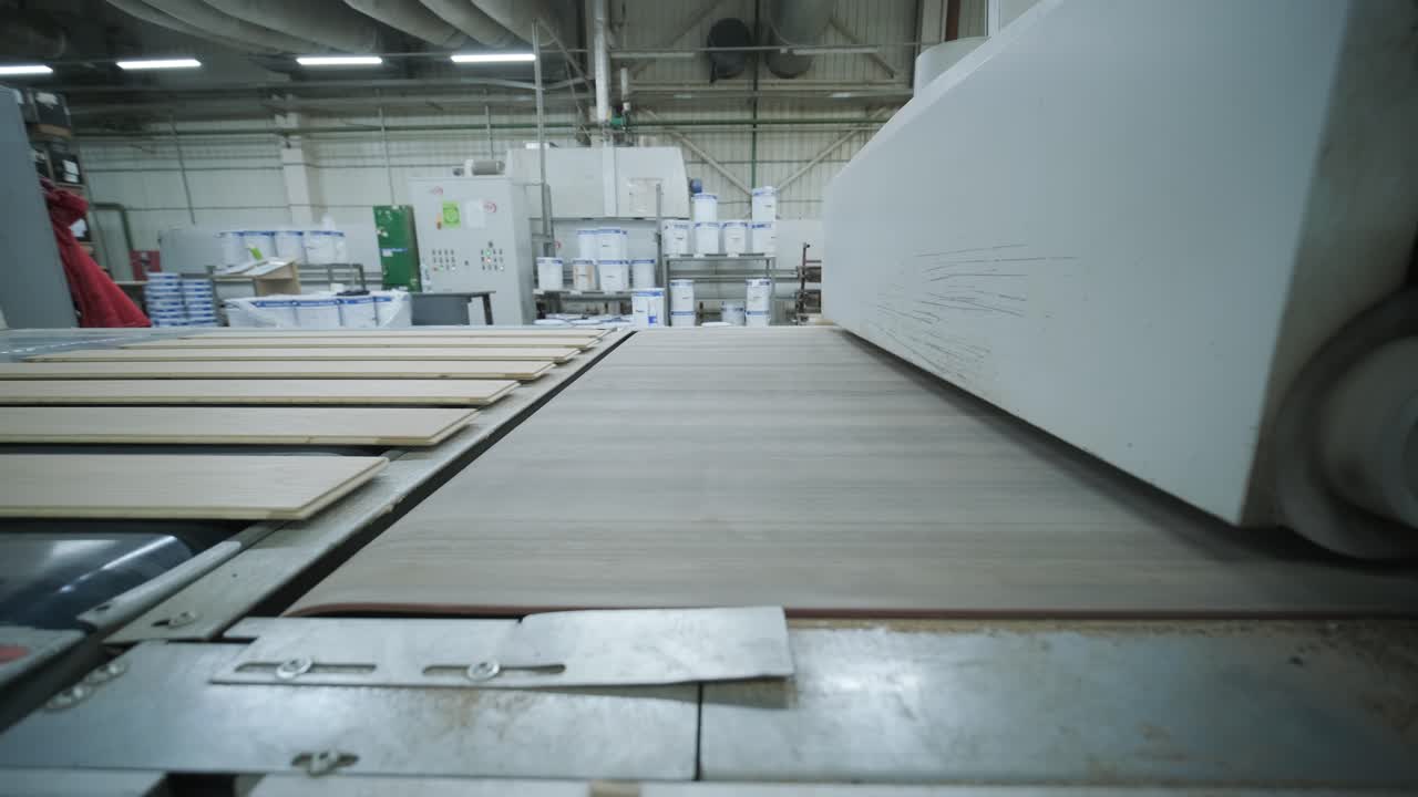 Assi di legno che si muovono su un nastro trasportatore automatizzato in fabbrica.