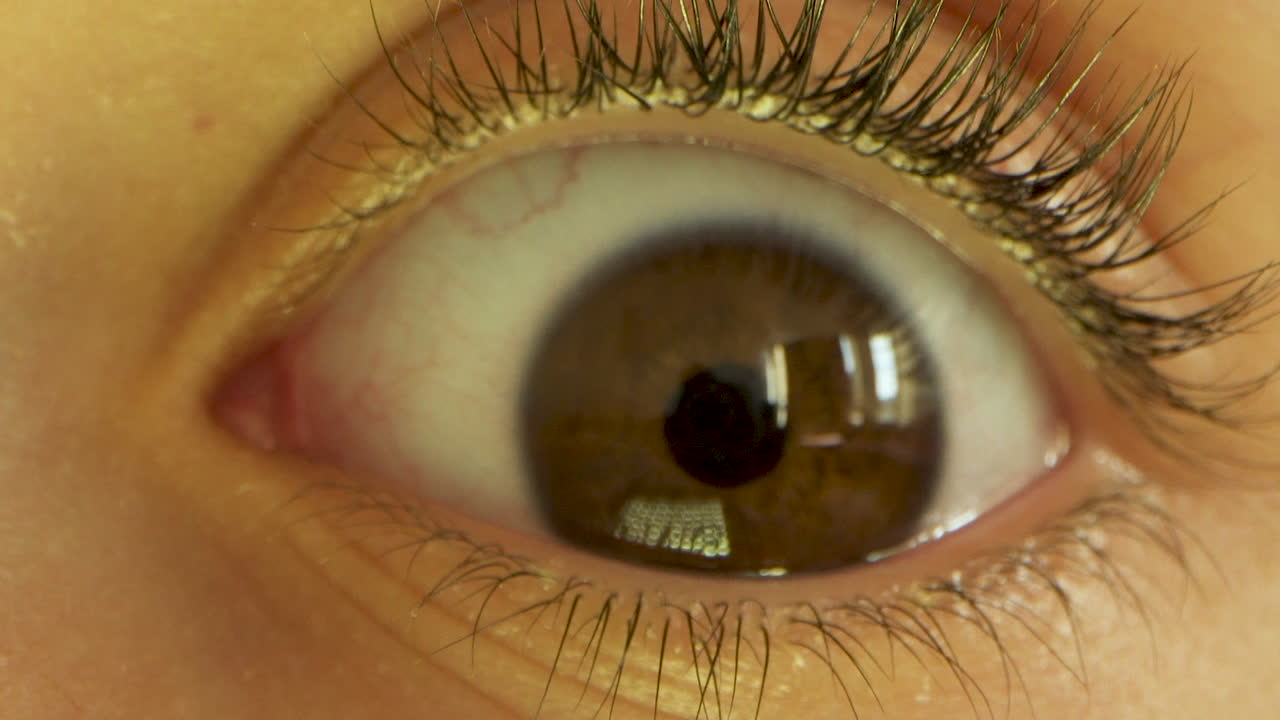 крупный план глаза маленького ребенка, который моргает, смотрит и оглядывается по сторонам