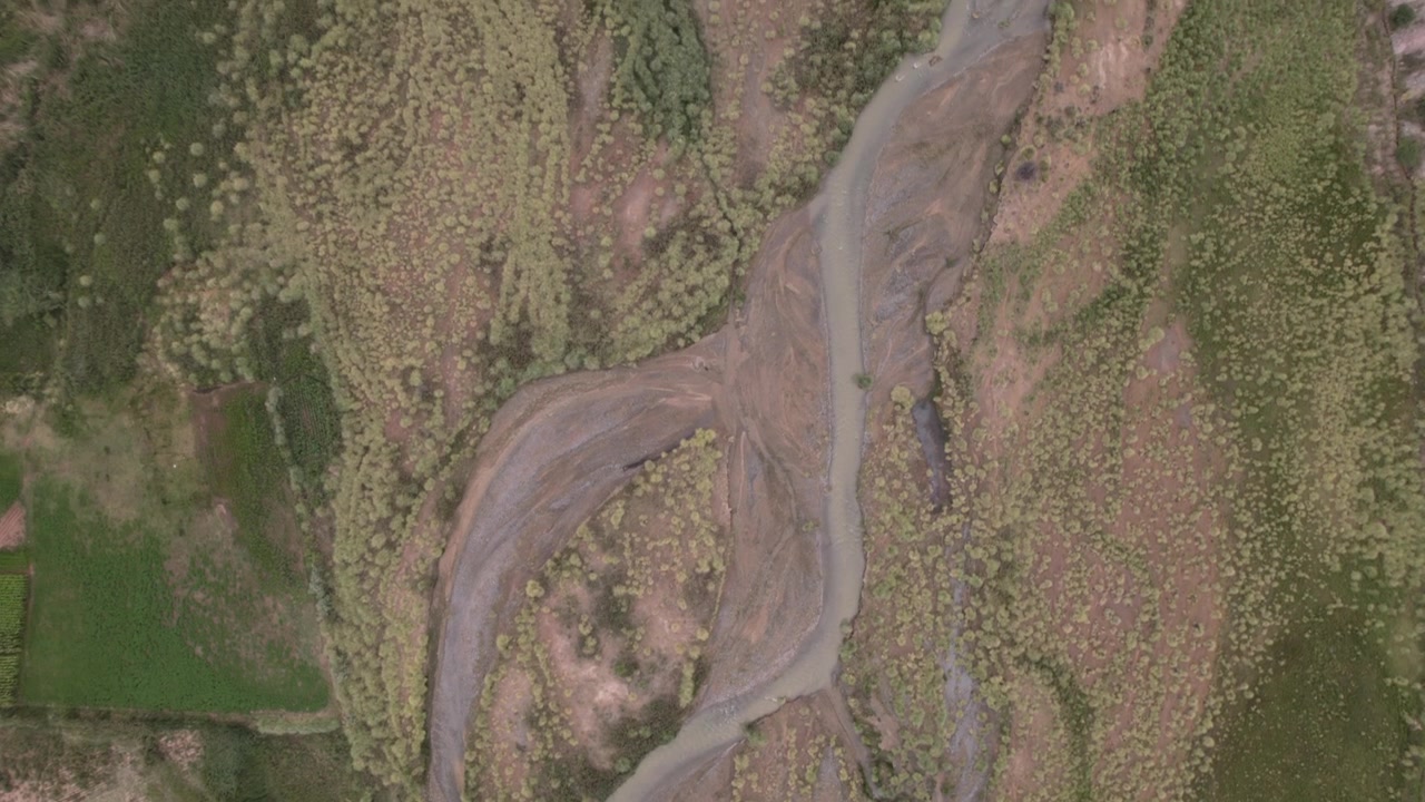 Topdown 4K drone aerial view of La Poma, Salta, Argentina. Stunning Andean landscape with red rock mountains, green valleys and a river crossing the dramatic canyon scenery.