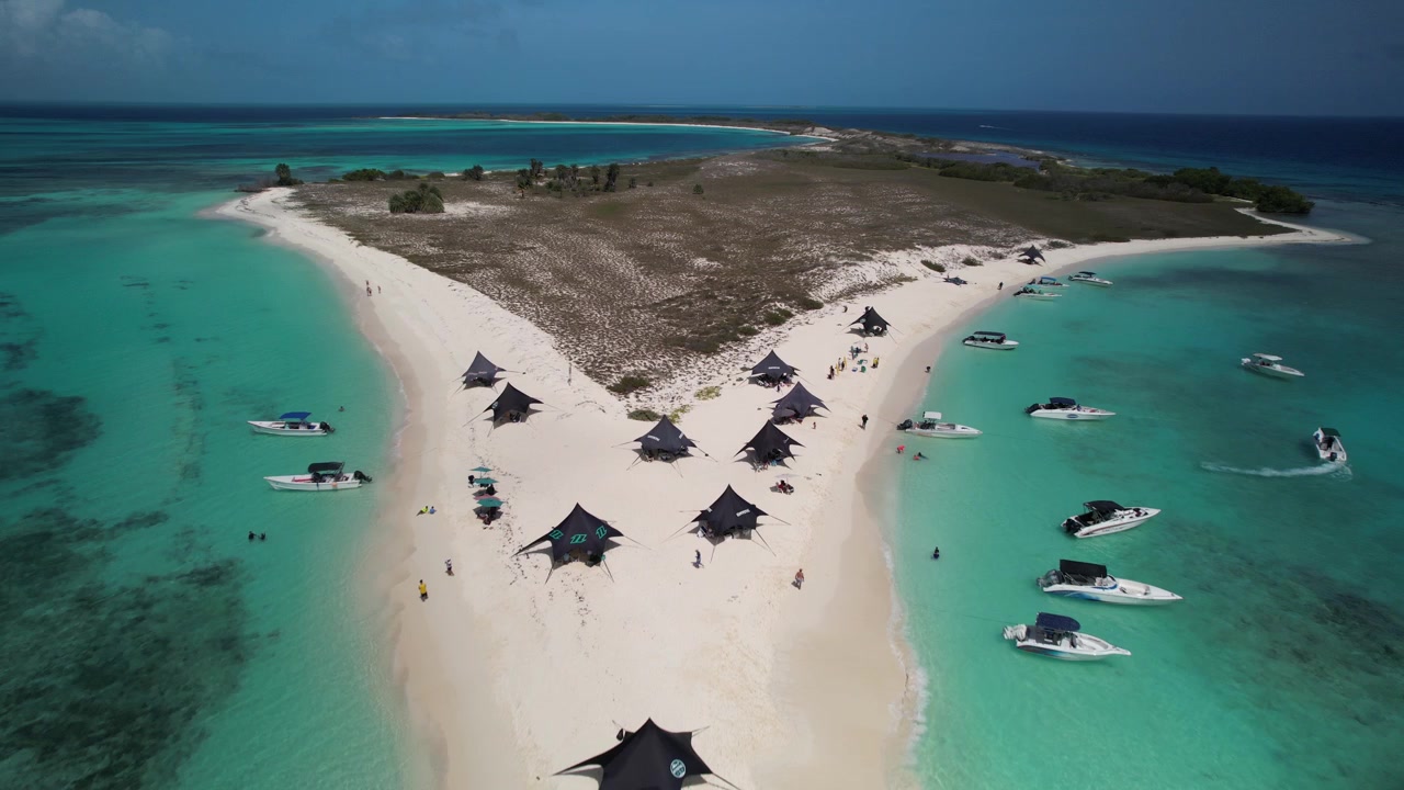 Vista aerea del mare turchese, della spiaggia sabbiosa e delle persone che si rilassano sull'isola di Cayo de Agua
