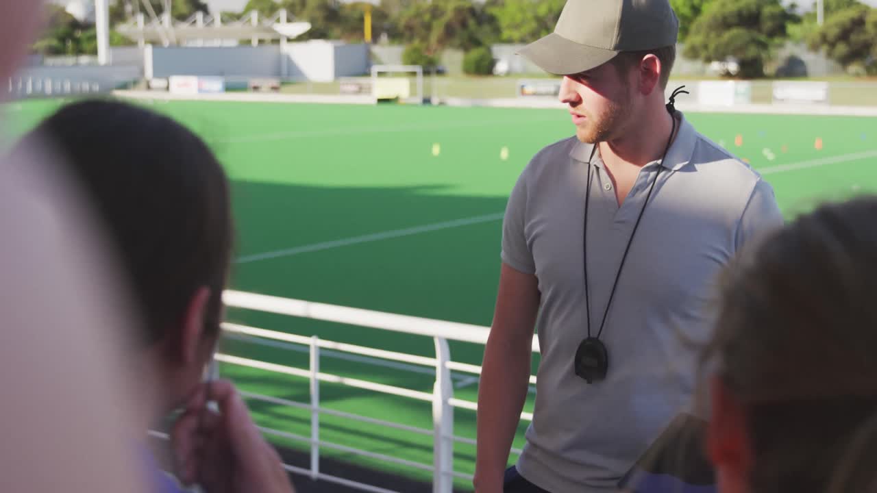 entrenador de hockey hablando con jugadoras
