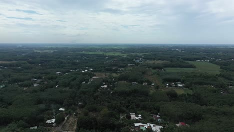 Aerial-fly-in-shot-of-Cu-Chi,-Vietnam-with-farms,-forests-on-sunny-day-with-blue-sky