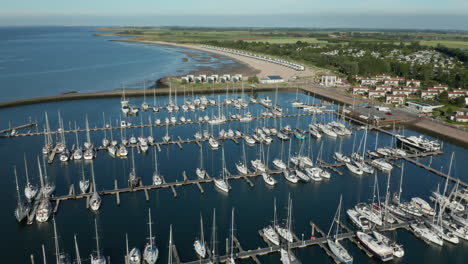 Ships-Dock-At-Roompot-Marina-Harbour-With-A-View-Of-Roompot-Beach-Resort-In-Kamperland,-Netherlands