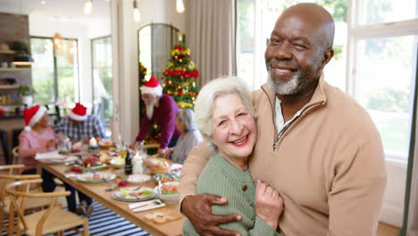 Feliz-Y-Diversa-Pareja-De-Ancianos-Abrazándose-Después-De-La-Comida-Navideña-Con-Amigos,-Espacio-Para-Copiar,-Cámara-Lenta