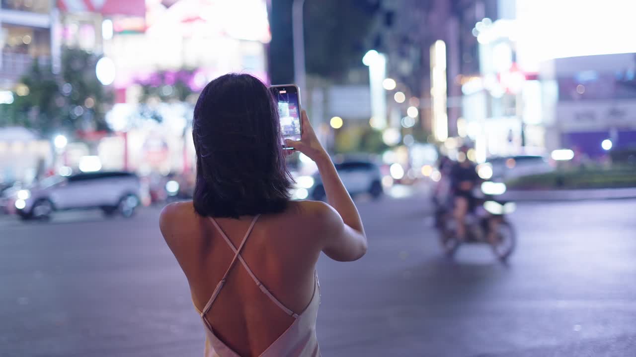 Donna che scatta una foto di notte in città