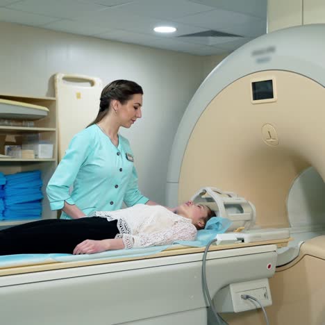 magnetic resonance image device in hospital. female patient lying in mri machine and medical worker controls the procedure. advanced medicine.