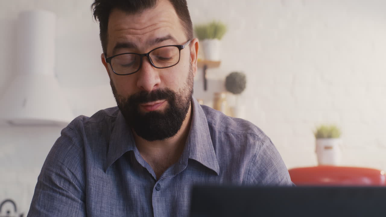 hombre trabajando en una computadora portátil en casa