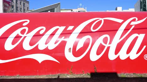 Coca-Cola Logo on a Red Wall in an Urban Setting