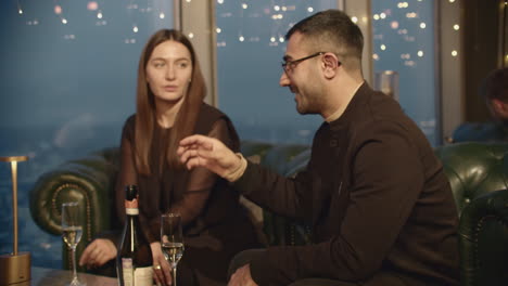 couple in conversation at a high-end rooftop restaurant