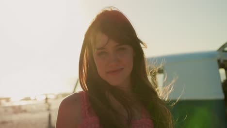 retrato de una mujer joven de pie en una playa sonriendo 4k