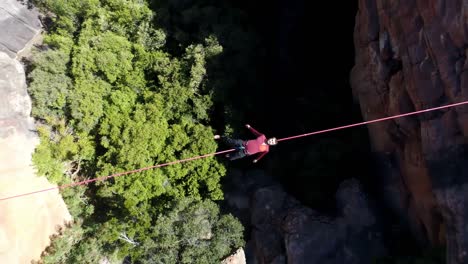 male highliner lying on a rope over rocky mountains 4k