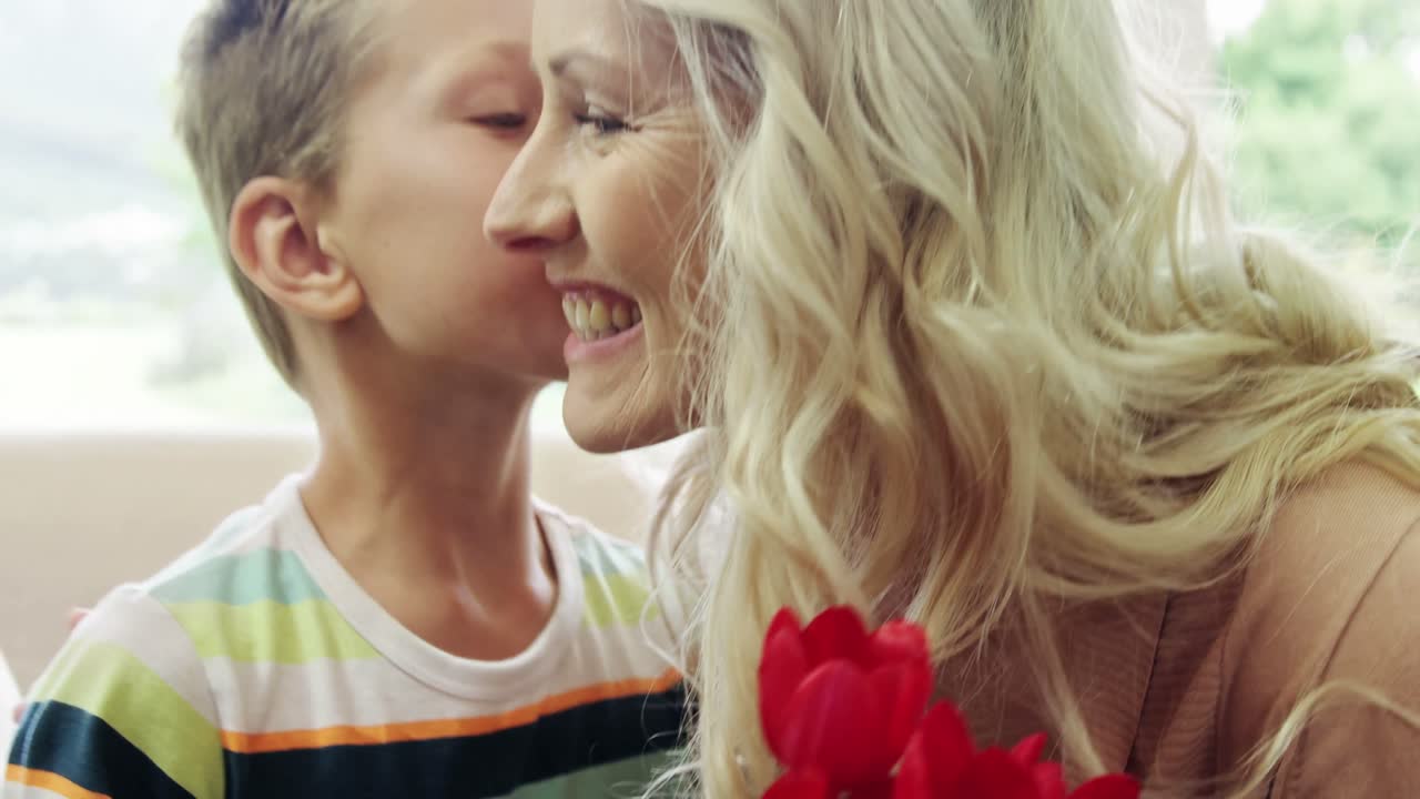 아들 은 어머니 에게 꽃 어리 를 선물 하고 있다