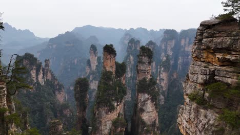 zhangjiajie's sandstone pillars stand tall amidst mist and greenery, offering a stunning natural spectacle shaped over millions of years.