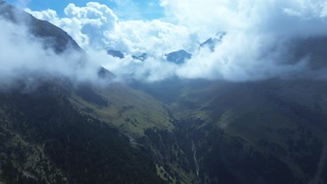 zoom in over a dramatic mountain valley with clouds rolling through, shot in valle de ip, aragon, spain