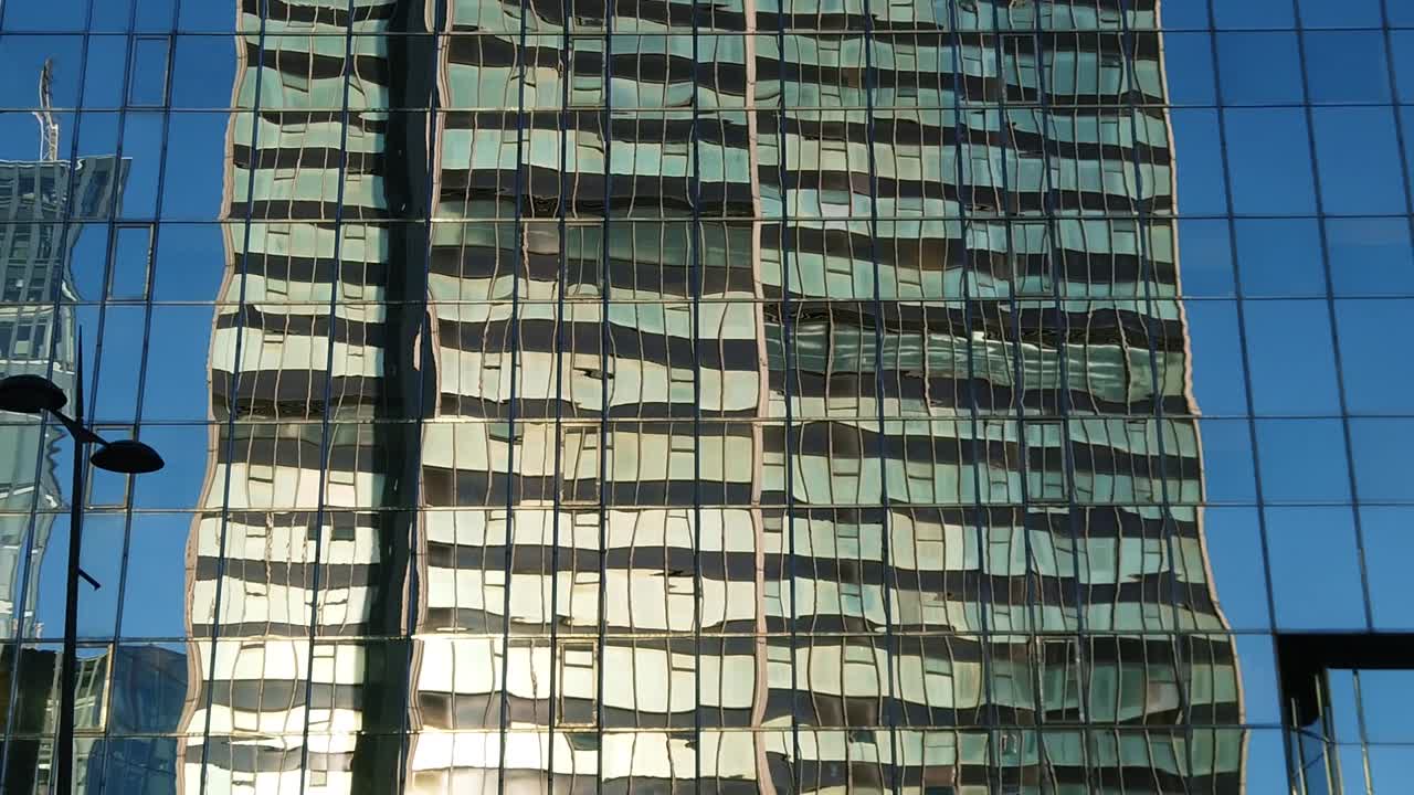 Distorted reflection of a glass tower in London on a sunny day, slow motion