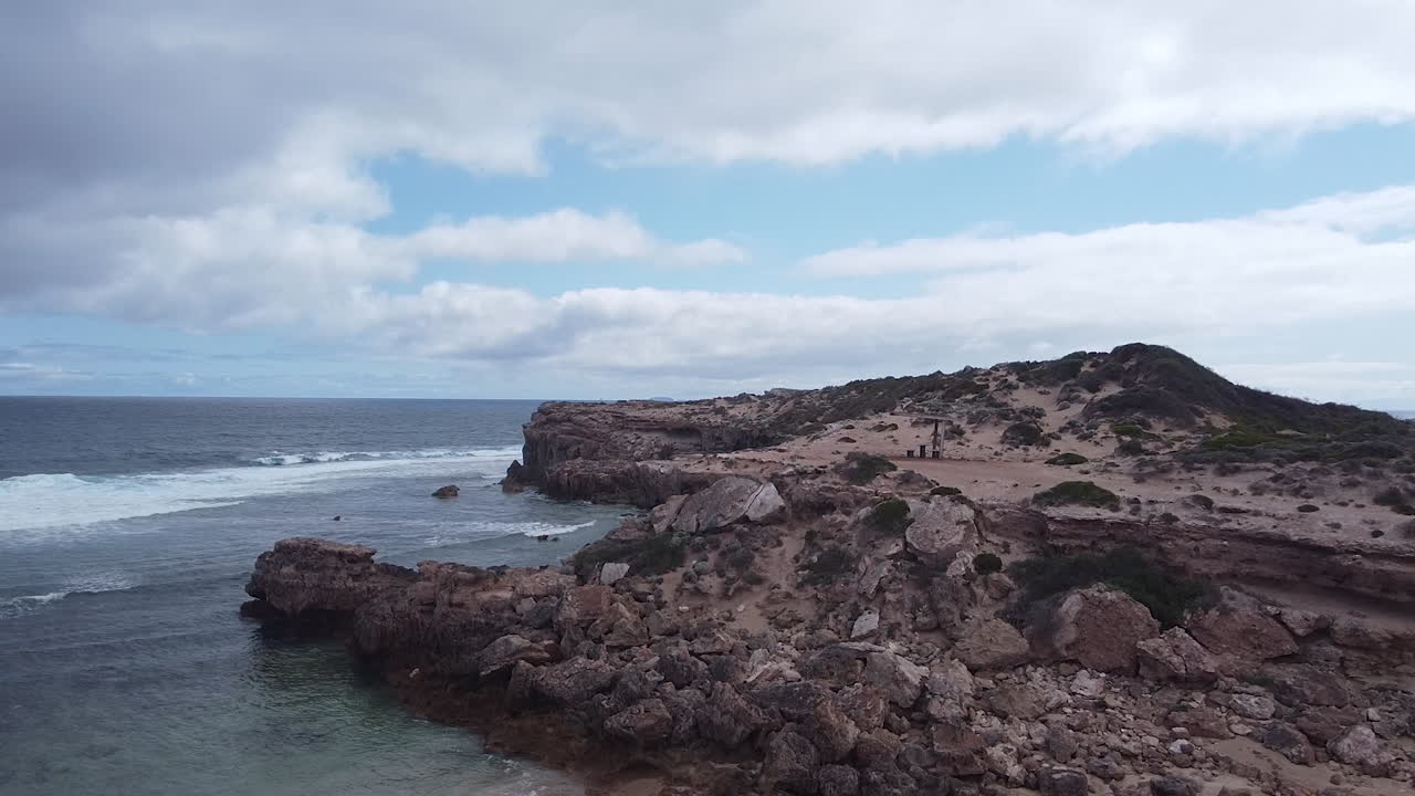 las suaves olas del mar se acercan a un acantilado estéril desprovisto de vida vegetal