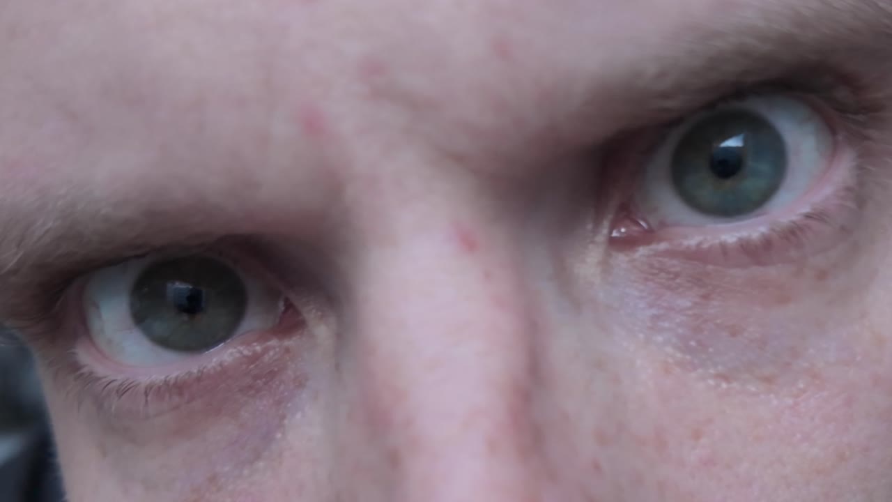 Macro shot of eyes reflecting screen light representing disinformation confusion