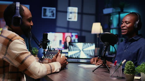 Cheerful-man-listening-to-guest-live-during-broadcasting-session-for-internet-show