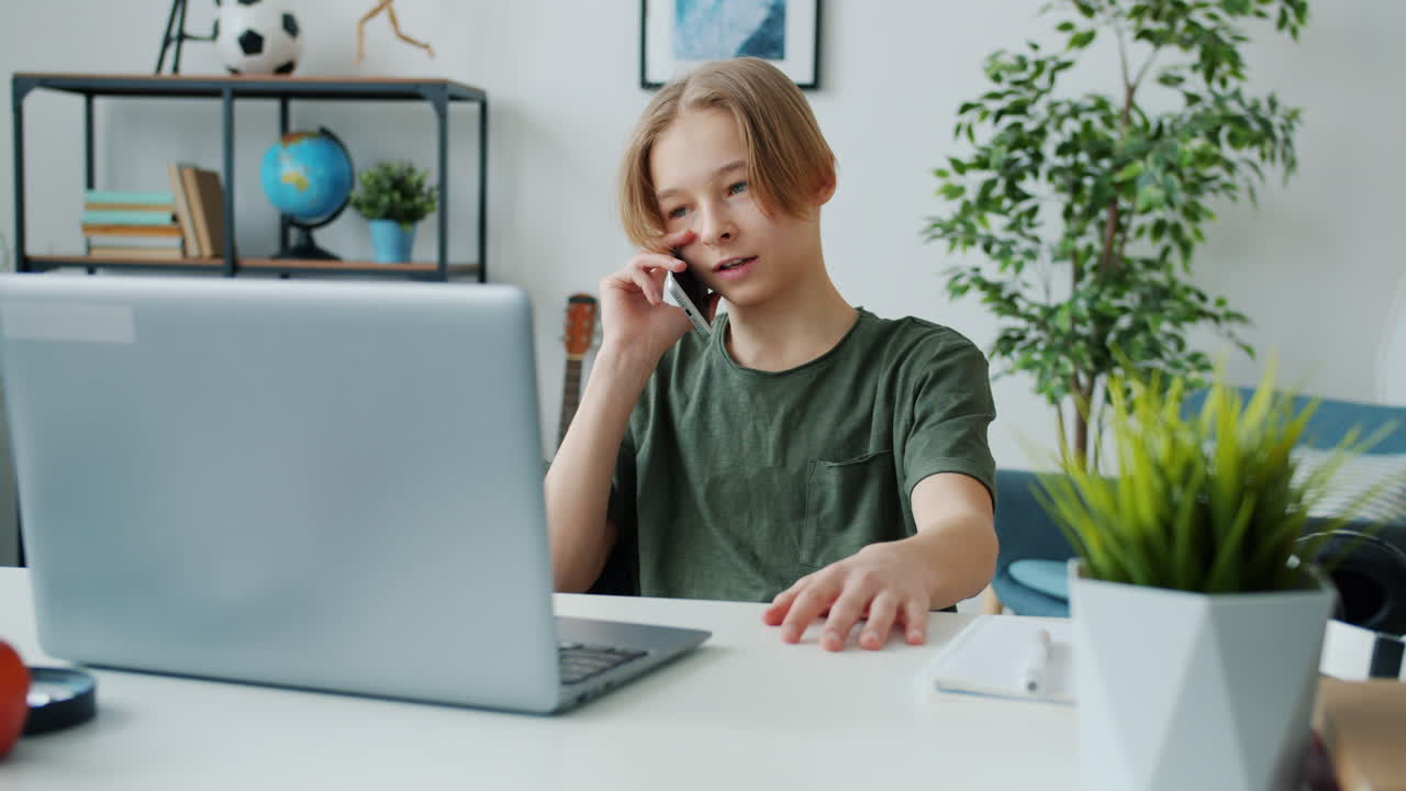 Teenager Talking on Phone While Using Laptop