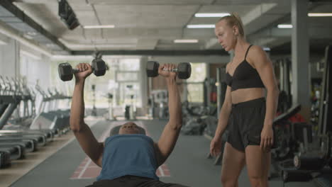 front view of caucasian female monitor and an athletic african american man in the gym.