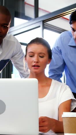 business executives discussing over laptop and digital tablet