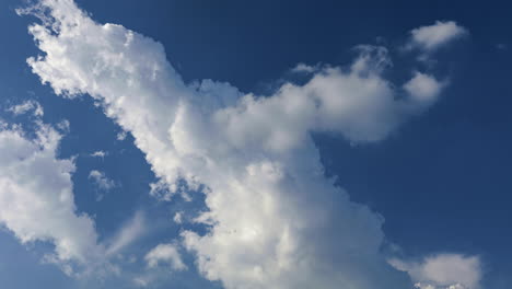 4k time lapse of very white clouds moving in interesting way against a stark blue sky background