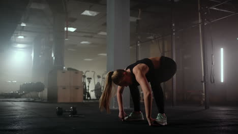 Eine-Frau-Macht-Nach-Dem-Training-Dehnübungen-In-Einem-Dunklen-Fitnessraum.-Fitness-Frau-Trainiert-Im-Dunklen-Fitnessstudio-Ihre-Rumpfmuskulatur