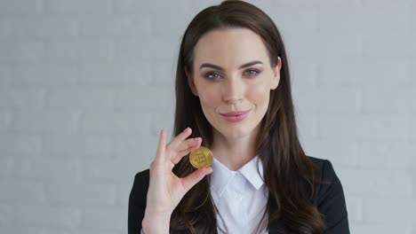 businesswoman showing bitcoin to camera