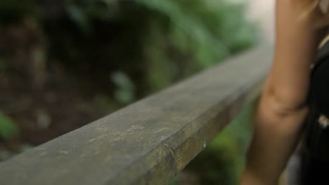 cámara lenta de una mujer bajando los escalones y poniendo su mano en el pasamanos de madera