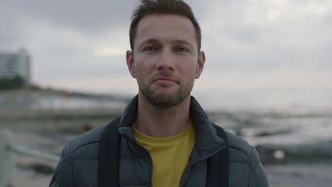 close-up-portrait-of-man-standing-on-seaside-beach-looking-serious-at-camera