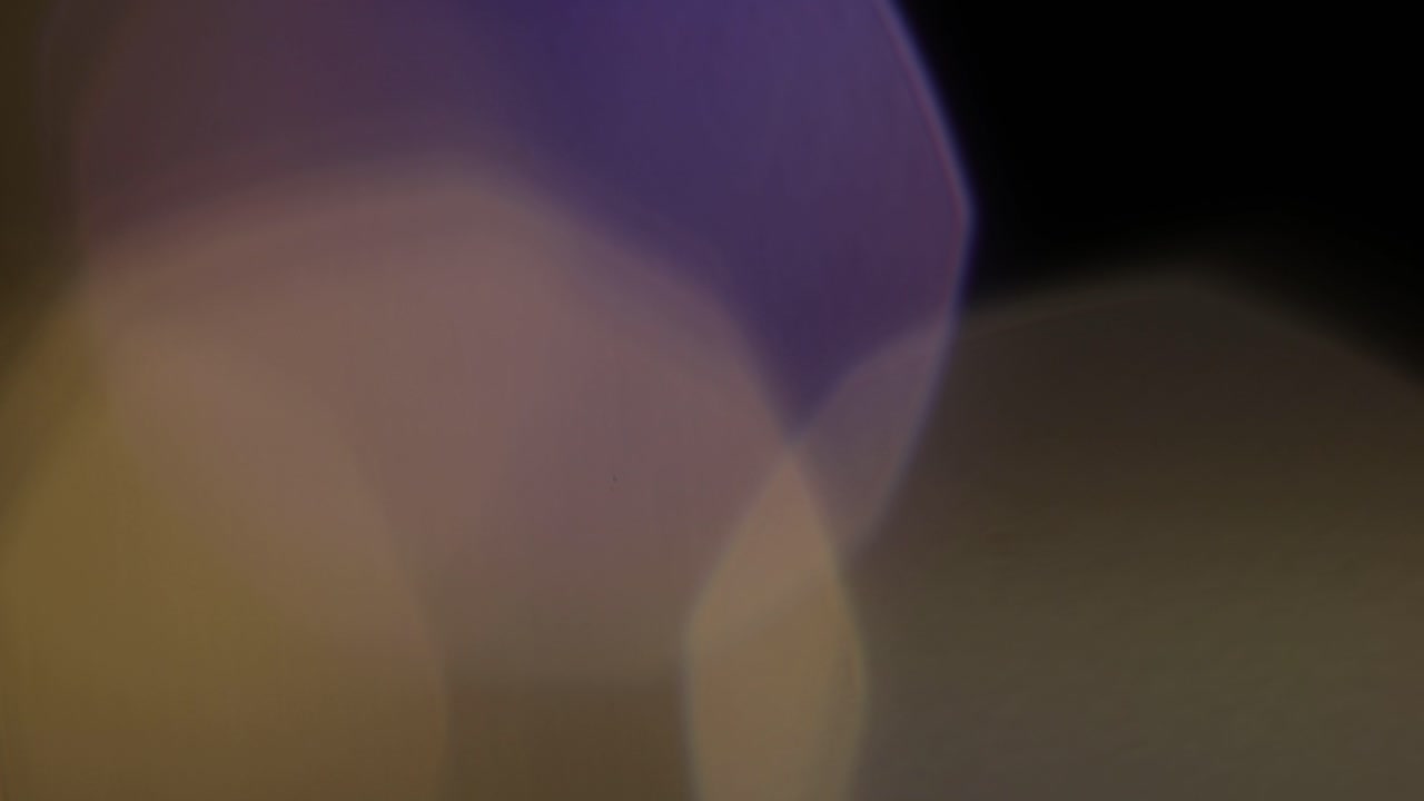 다채로운 빛은 검은 바탕에 4k 영상을 유출합니다. 스타일링 비디오, 전환, 보케 효과.