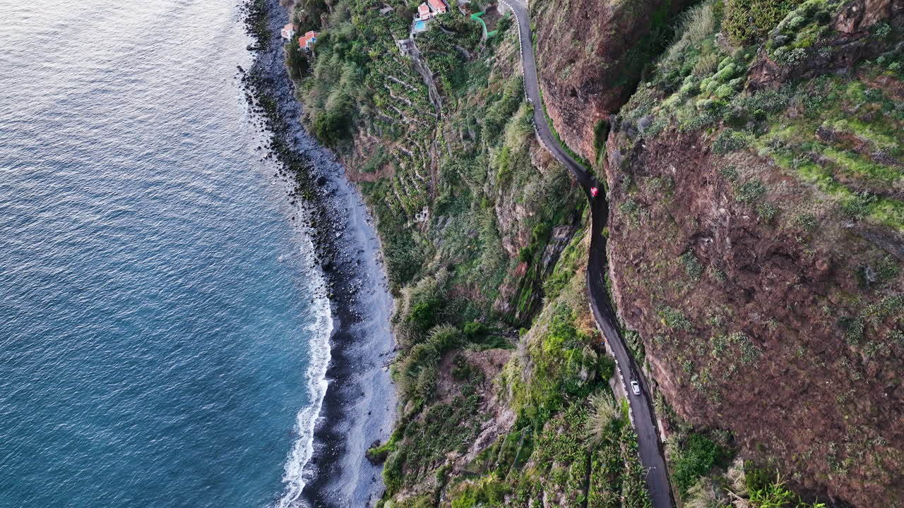 Auto su una pericolosa strada a strapiombo sotto la cascata di Anjos, Madeira.