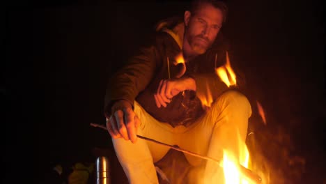 hombre cocinando comida en el fuego del campamento en el bosque 4k