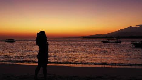 philippines, worried woman with the hands on her hand standing on the sandy beach during the sunset