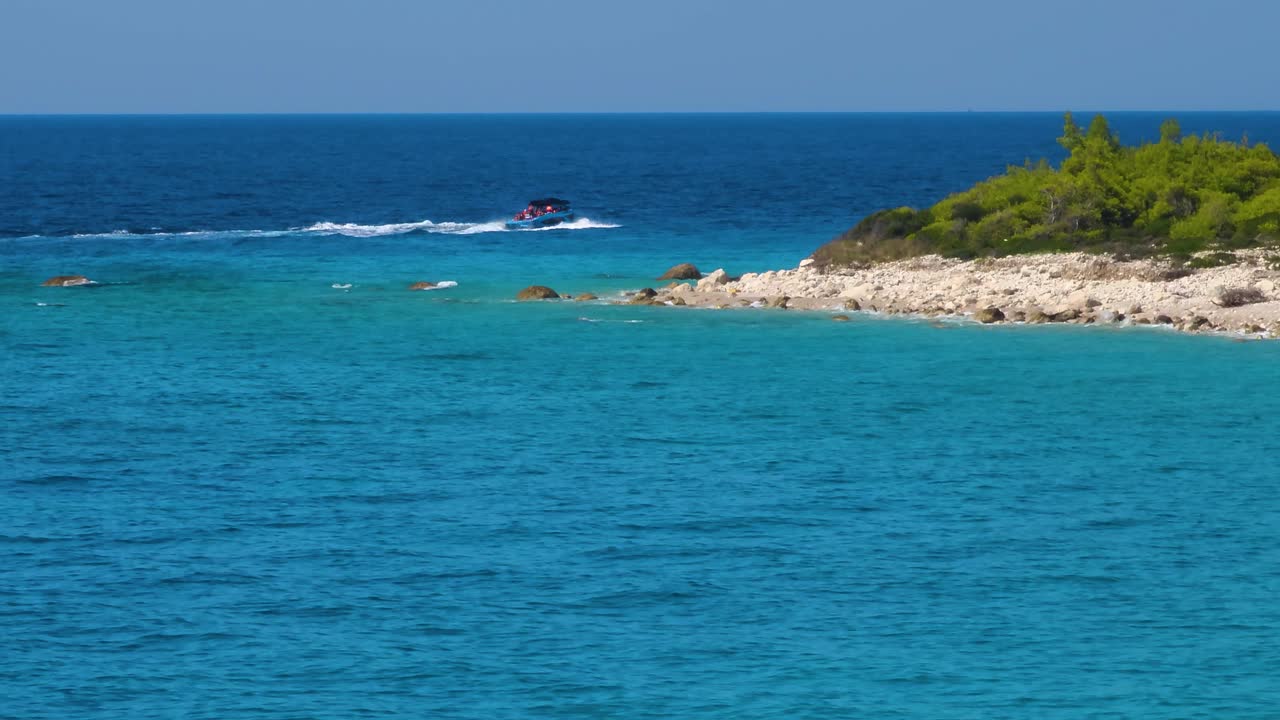 Tour Boat with Excited Tourists Sets Sail from the Cape, Venturing Towards the Vast Open Sea in Albania