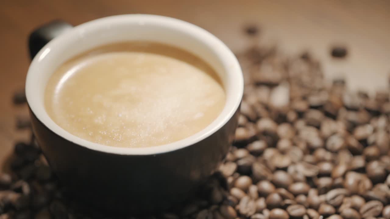 신선한 커피 콩 슬로우 모션으로 둘러싸인 나무 테이블에 커피 한 잔 위에 증기