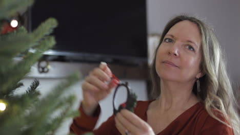 Portrait-Of-A-Beautiful-Caucasian-Lady-At-Home-Decorating-Christmas-Tree-At-Winter