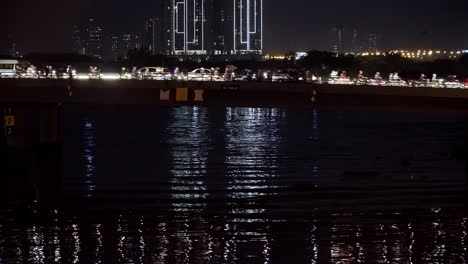 Gente-Cruzando-Un-Puente-Con-Mucho-Tráfico-Por-La-Noche