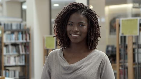 hermosa mujer afroamericana posando en la biblioteca