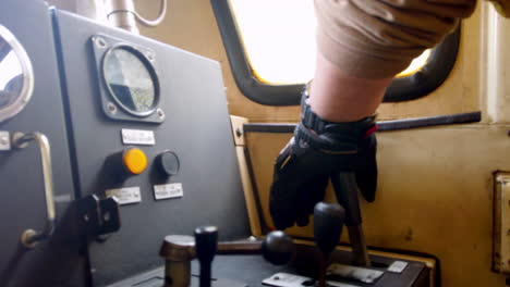 Close-up-of-a-train-driver's-hand-operating-controls-in-the-cabin-during-a-journey-in-Alausi,-Ecuador