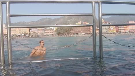 Joven-Bañándose-En-El-Río-Sagrado-Ganga-Por-La-Mañana-Desde-Un-Video-De-ángulo-Plano-Tomado-En-Haridwar-Uttrakhand-India