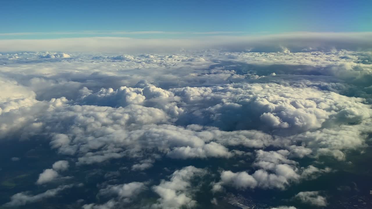Bird's Eye View above Majestic Clouds from Airplane Window