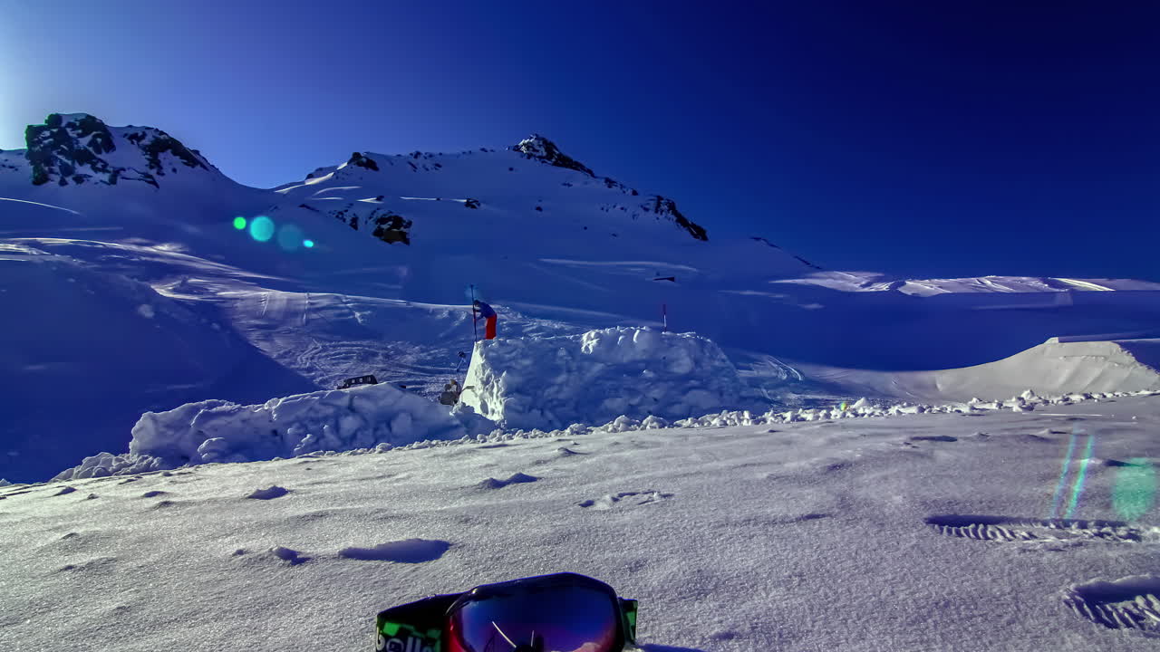 time-lapse de un equipo de trabajadores construyendo una pista única para patinaje sobre hielo a lo largo de una ladera de montaña cubierta de nieve en un día soleado