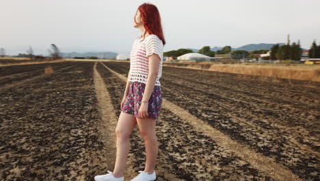 red haired woman in a dry field