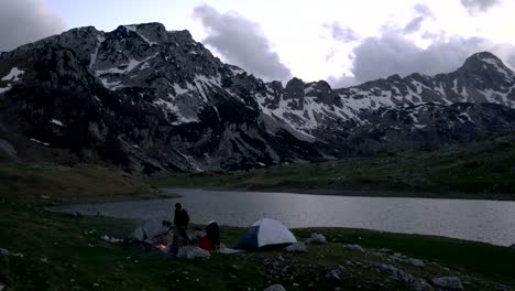 couple of travelers at dusk near a campfire
