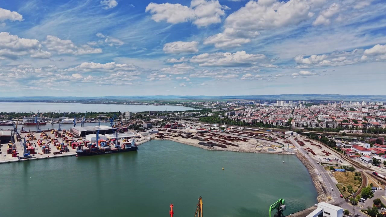Vista costiera del porto trafficato con navi e città sullo sfondo