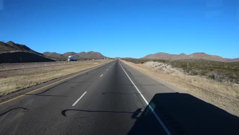 pov while driving along the interstate with only oncoming traffic in new mexico on a sunny day