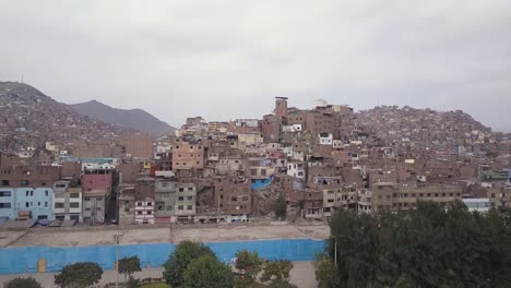 a striking view of a densely populated hillside with colorful buildings. earthy tones contrast with blue and green accents. ideal for urban studies, social documentaries, and architecture blogs.